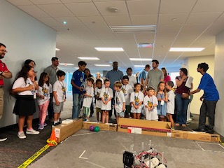 Children and families attending a Techs Mechs hands-on robot demonstration at Hilton Kids Day